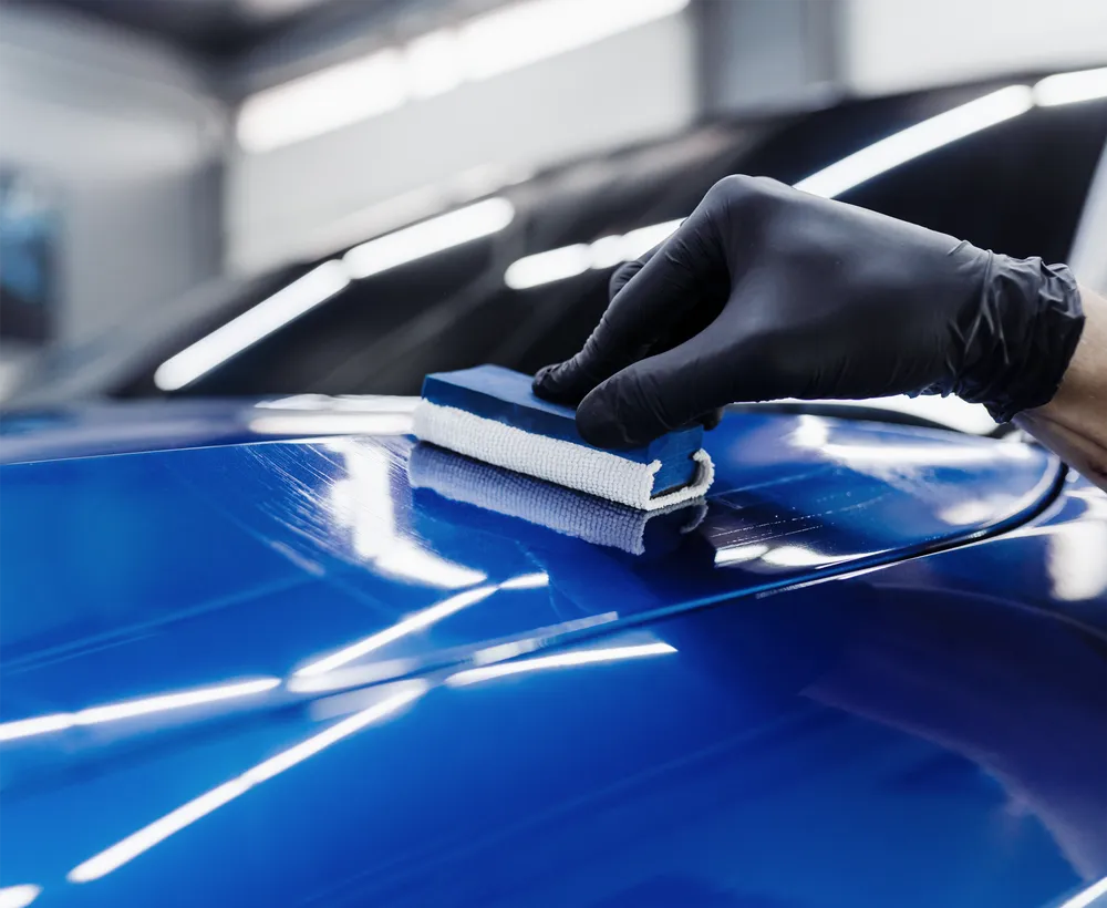 Ceramic coating being applied to a car panel by a Zivent technician